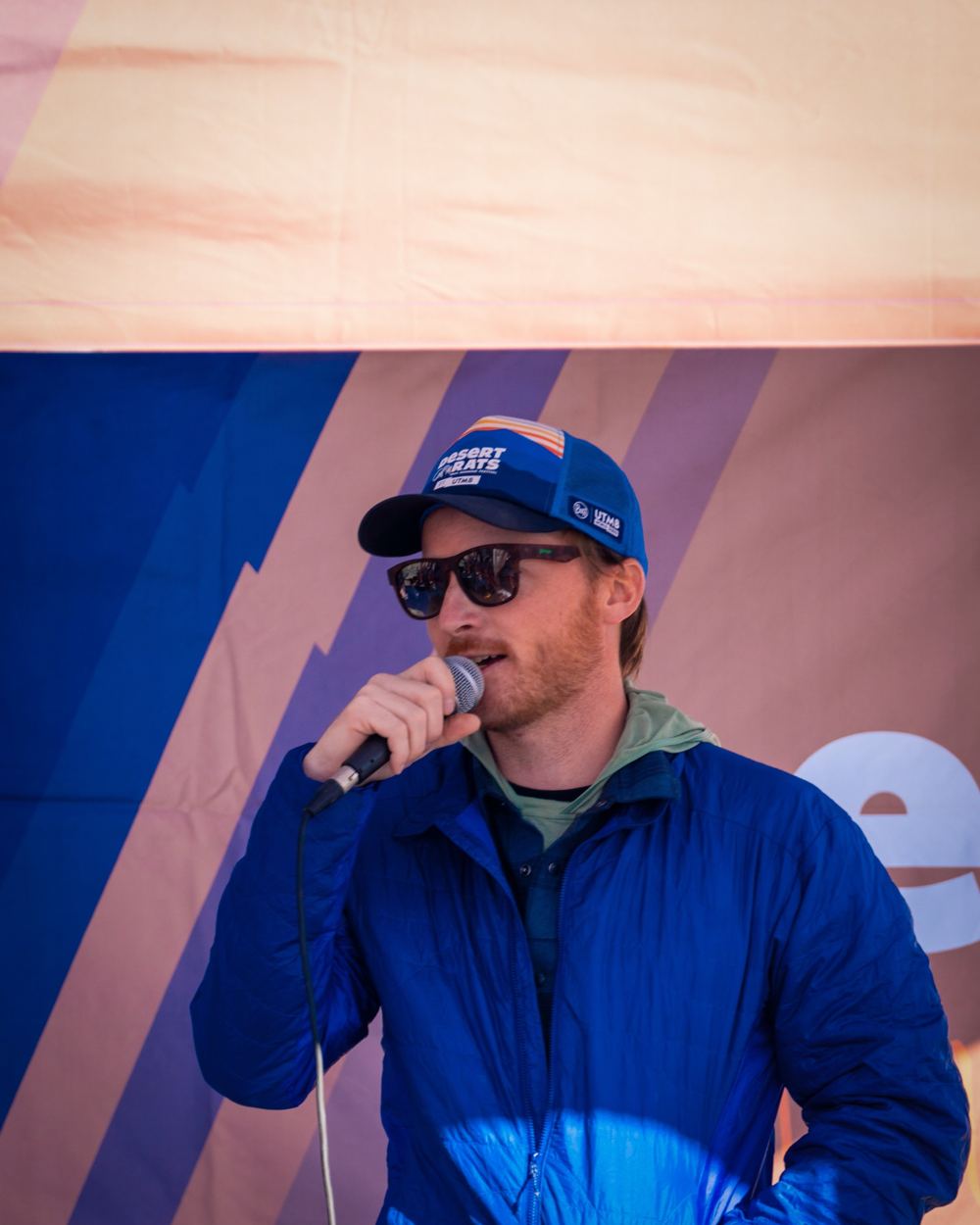 Nick Edwards speaking into a microphone in a blue jacket